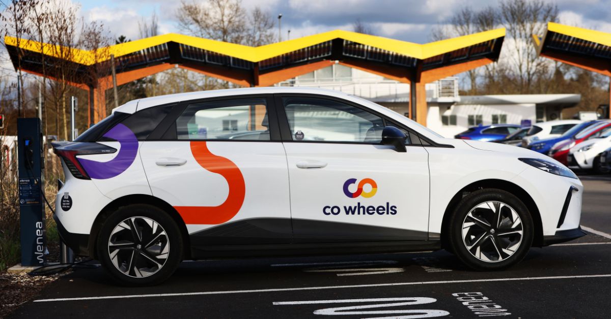 A car-club electric vehicle with the canopy of a charging hub in the background.