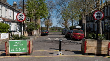 A residential, tree-lined street in a low-traffic neighbourhood on a sunny day in England