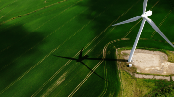 Aerial shot of the wind turbine next to a field