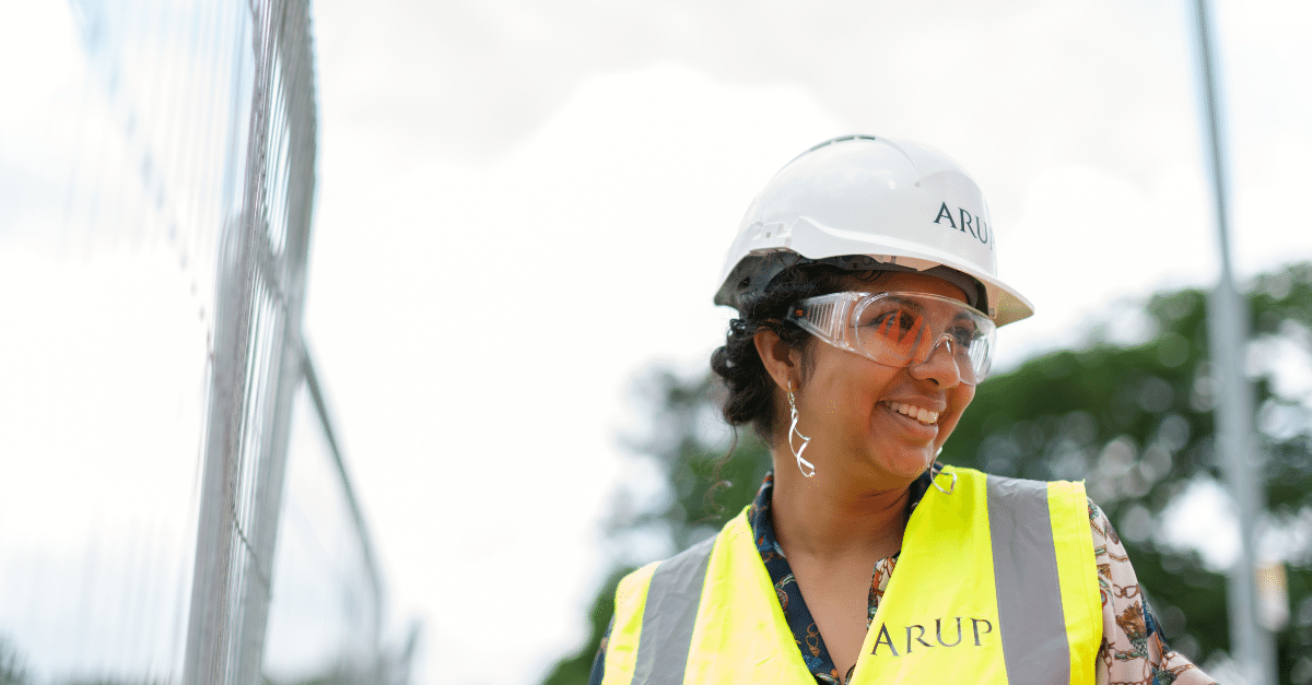 Female civil engineer on site in a high-vis vest and white hard hat