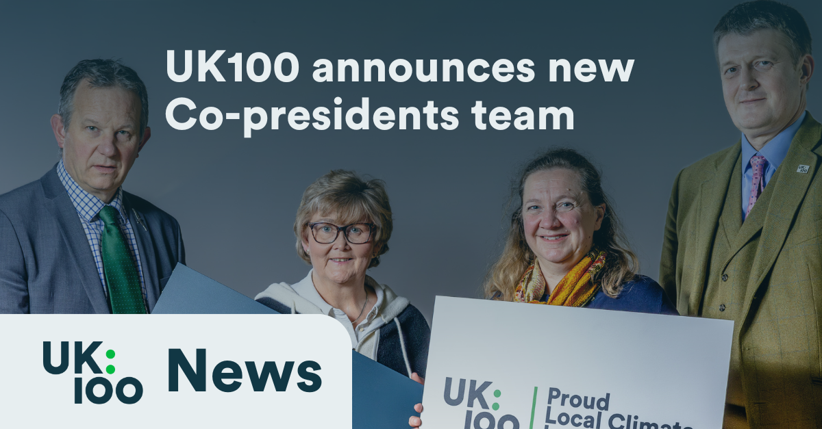 "UK100 announces new Co-presidents team - Four professionals in business attire against a blue background, holding UK100 branded materials including a 'Proud Local Climate Leader' sign. The image accompanies a news announcement about UK100's leadership changes."