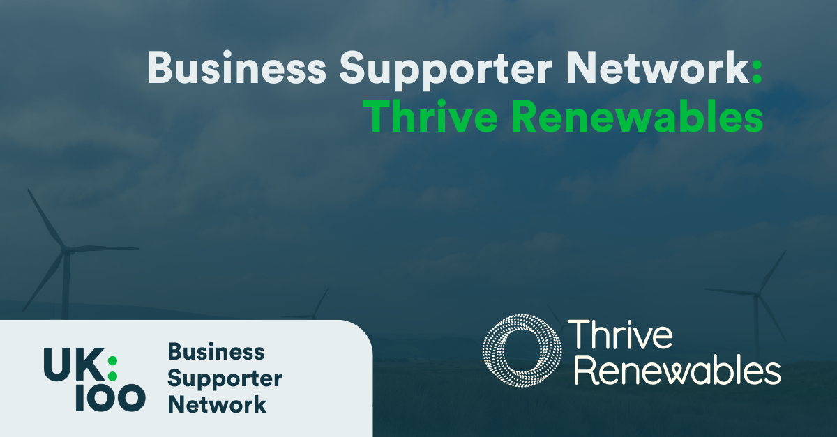 A promotional banner featuring the Business Supporter Network heading in white text overlaid on a dark, blurred background image of a lorry on a tree-lined road. The banner includes two logos: the UK100 Business Supporter Network logo on the left, showing 'UK:100' in a modern design, and the Thrive Renewables logo on the right. The overall colour scheme's dark blue-green in tone
